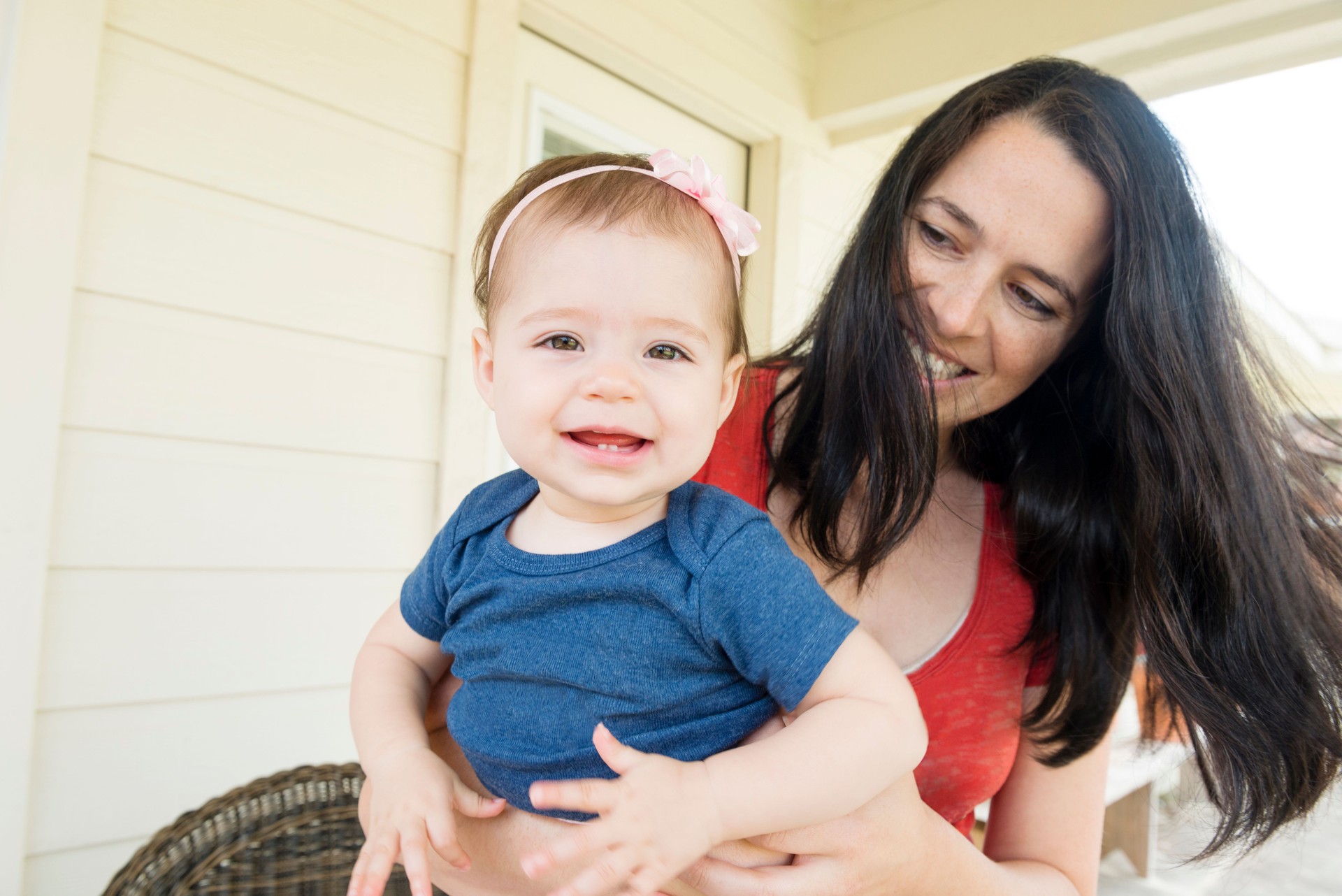 Millennial Mother Holding Baby Girl Outside Home USA